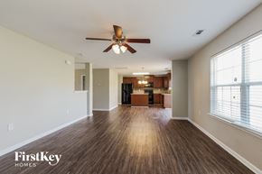 Dallas house for rent - an empty living room with a ceiling fan and a kitchen