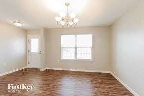 Dallas house for rent - the spacious living room with wood flooring and a chandelier