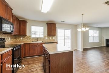 Dallas house for rent - a kitchen with wooden cabinets and a white counter top