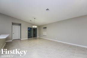 Port St. Lucie house for rent - A spacious empty room with a door and a window.