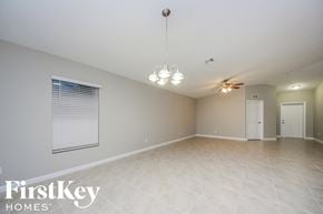 Port St. Lucie house for rent - A spacious room with a fan and a chandelier.