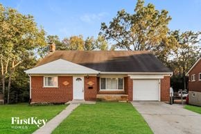 Cincinnati house for rent - the front of a brick house with a driveway and grass