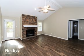 Lakeland house for rent - A spacious room with a stone fireplace and wood flooring.