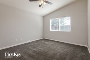 Phoenix house for rent - the spacious bedroom with carpeted flooring and a ceiling fan