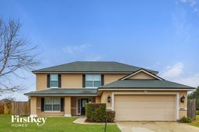 Green Cove Springs house for rent - a yellow house with a garage and a blue sky
