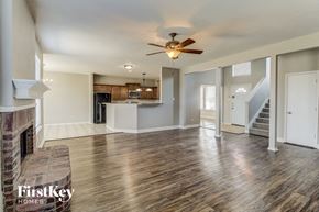 Sachse house for rent - A spacious living room with wood flooring and a fireplace.