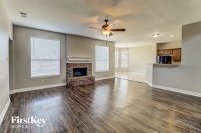 Sachse house for rent - A spacious living room with wood flooring and a fireplace.