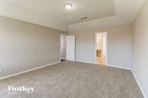 Sachse house for rent - A spacious room with a carpeted floor and two open doors.