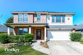 Magnolia house for rent - a large brick house with a white garage door