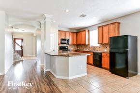 Magnolia house for rent - a kitchen with black appliances and wooden cabinets