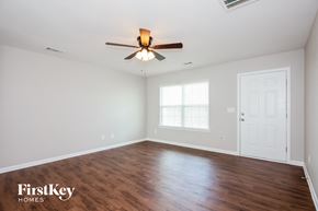 Dallas house for rent - A room with a ceiling fan and wooden flooring.