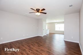 Dallas house for rent - A room with a ceiling fan and wooden floors.