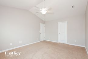 Dallas house for rent - A spacious room with a carpeted floor and a ceiling fan.