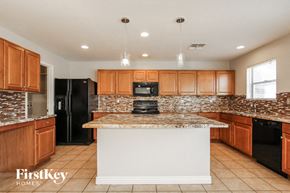 Phoenix house for rent - a kitchen with wooden cabinets and a counter top