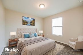 Lehigh Acres house for rent - A bedroom with a large bed and a painting on the wall.