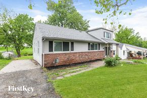Independence house for rent - A house with a grey roof and a brick wall is shown with a grassy lawn in front.