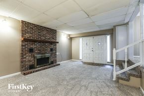 Independence house for rent - A room with a brick fireplace and a carpeted floor.