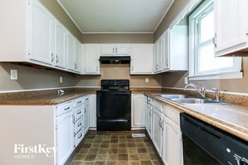 Independence house for rent - A kitchen with white cabinets and a black oven.