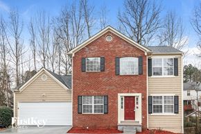 Duluth house for rent - a brick house with a red front door and a white garage