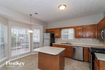 Duluth house for rent - a kitchen with wooden cabinets and stainless steel appliances and a white counter top