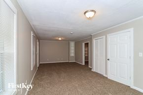 Duluth house for rent - a spacious living room with a carpeted floor and white doors