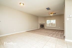 Forney house for rent - an empty living room with a fireplace and tile flooring