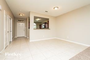 Forney house for rent - an empty living room with a white tile floor and a white door