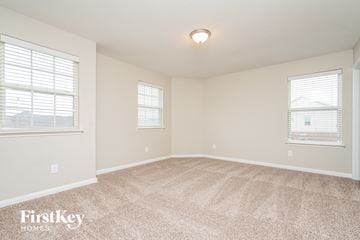 Forney house for rent - a spacious living room with carpet and two windows