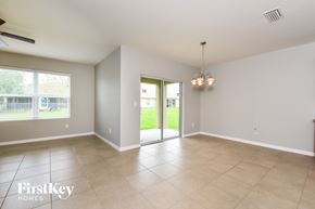 Cape Coral house for rent - an empty living room with a sliding glass door to the yard