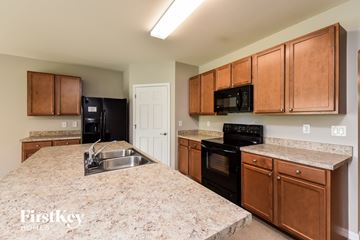 Cape Coral house for rent - a kitchen with black appliances and granite counter tops