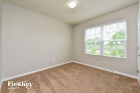 Cape Coral house for rent - a bedroom with a large window and a carpeted floor