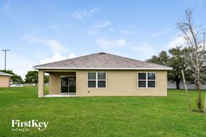 Cape Coral house for rent - a small tan house in a grassy yard
