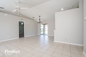 Lehigh Acres house for rent - a clean empty living room with a ceiling fan and white walls