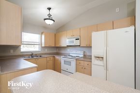 Lehigh Acres house for rent - a kitchen with white appliances and wooden cabinets