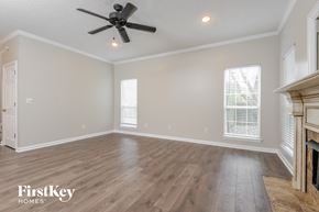 Helena house for rent - the living room with hardwood floors and a fireplace and a ceiling fan