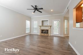 Helena house for rent - an empty living room with a fireplace and a ceiling fan