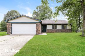 Indianapolis house for rent - a brick house with a lawn and a white garage door