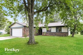 Indianapolis house for rent - a brick house with a large tree in the yard