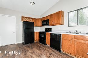 Indianapolis house for rent - a kitchen with black appliances and wooden cabinets