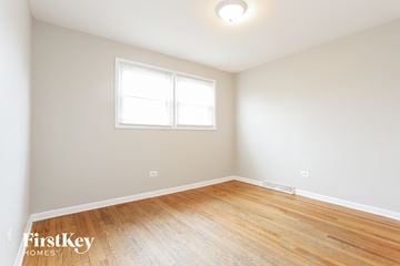 Blue Island house for rent - a living room with wood floors and white walls and a window