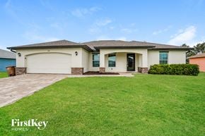 Cape Coral house for rent - A house with a garage and a lawn in front.