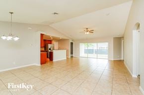 Cape Coral house for rent - A spacious living room with a fan and a chandelier.
