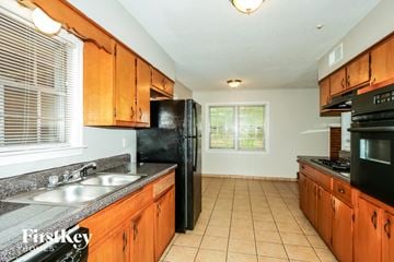 Memphis house for rent - A kitchen with wooden cabinets and black appliances.