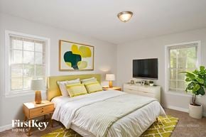 Memphis house for rent - A bedroom with a bed, nightstand, and a painting on the wall.