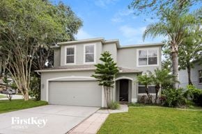 Tarpon Springs house for rent - a white house with palm trees and a driveway