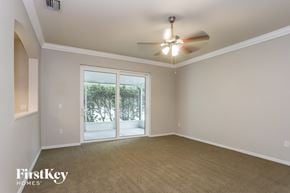 Tarpon Springs house for rent - an empty living room with a ceiling fan and a window