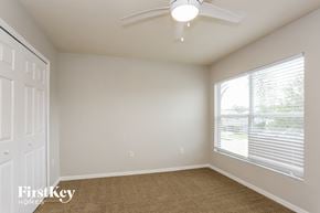 Tarpon Springs house for rent - a bedroom with a large window and a ceiling fan