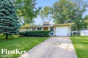 Florissant house for rent - A house with a driveway and a tree in front of it.