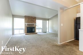 Florissant house for rent - A spacious living room with a fireplace and a large window.