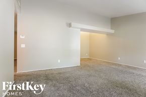 Florissant house for rent - A spacious room with a carpeted floor and a white wall.
